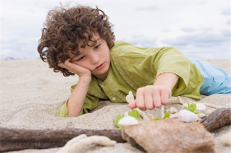 drift wood - Boy playing with sand on the beach Stock Photo - Premium Royalty-Free, Code: 6108-05864087