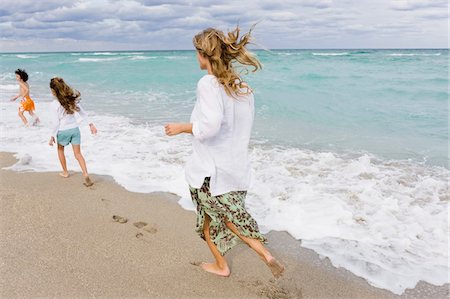 simsearch:6108-05860263,k - Woman with her children on the beach Stock Photo - Premium Royalty-Free, Code: 6108-05864019