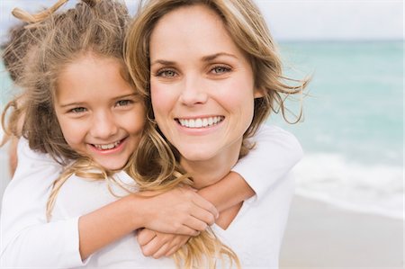 daughter piggyback at beach - Woman giving her daughter piggyback on the beach Stock Photo - Premium Royalty-Free, Code: 6108-05864021