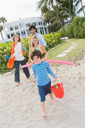 family, hotel - Family walking on the beach with a tourist resort in the background Stock Photo - Premium Royalty-Free, Code: 6108-05864152