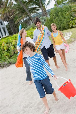 family, hotel - Family walking on the beach with a tourist resort in the background Stock Photo - Premium Royalty-Free, Code: 6108-05864178