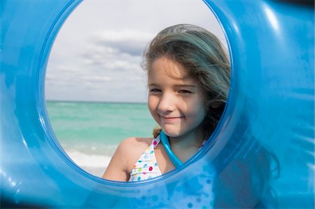 Girl looking through an inflatable ring Stock Photo - Premium Royalty-Free, Code: 6108-05864179