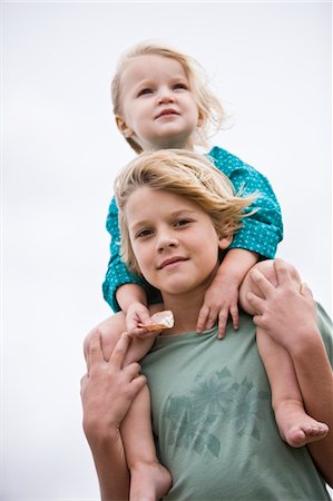 simsearch:6108-05860263,k - Boy carrying his sister on shoulders on the beach Stock Photo - Premium Royalty-Free, Code: 6108-05864104