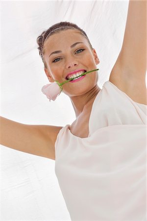simsearch:877-07460478,k - Fashion model holding rose between her teeth Stock Photo - Premium Royalty-Free, Code: 6108-05864332