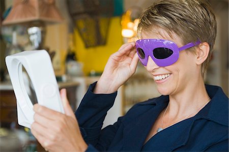 simsearch:6108-05864737,k - Woman wearing sunglasses in a store Stock Photo - Premium Royalty-Free, Code: 6108-05864722
