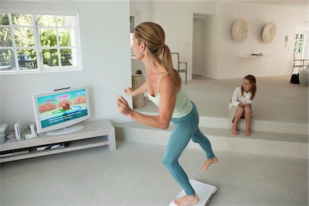 flexible young girls - Femme faisant l'aérobic d'étape et de regarder la télévision Photographie de stock - Premium Libres de Droits, Code: 6108-05864824