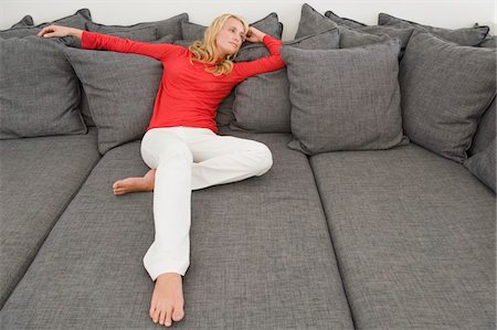 Woman reclining on a couch Stock Photo - Premium Royalty-Free, Code: 6108-05865366