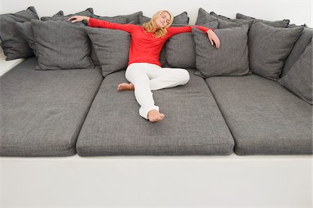 Woman reclining on a couch Stock Photo - Premium Royalty-Free, Code: 6108-05865370