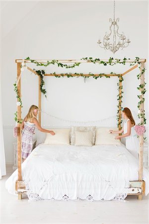 Two girls decorating a bed Stock Photo - Premium Royalty-Free, Code: 6108-05865498