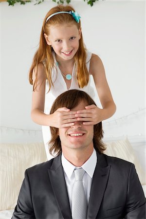 Girl covering man's eyes and smiling Stock Photo - Premium Royalty-Free, Code: 6108-05865527