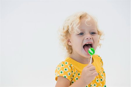 simsearch:6108-05865577,k - Girl licking green lollipop Stock Photo - Premium Royalty-Free, Code: 6108-05865607