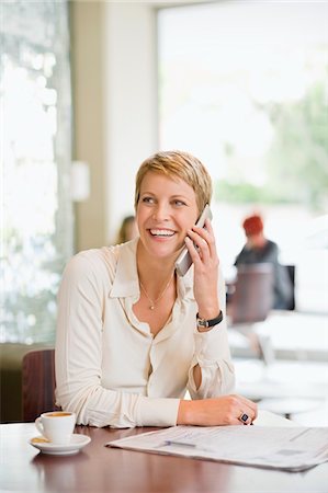simsearch:6108-05856772,k - Businesswoman sitting in a restaurant and talking on a mobile phone Stock Photo - Premium Royalty-Free, Code: 6108-05865771