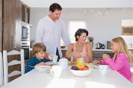 simsearch:6108-05863411,k - Family having breakfast at the dining table Stock Photo - Premium Royalty-Free, Code: 6108-05865793