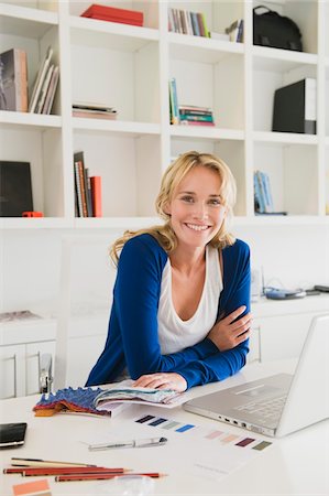 Businesswoman choosing color swatches and smiling Stock Photo - Premium Royalty-Free, Code: 6108-05865727