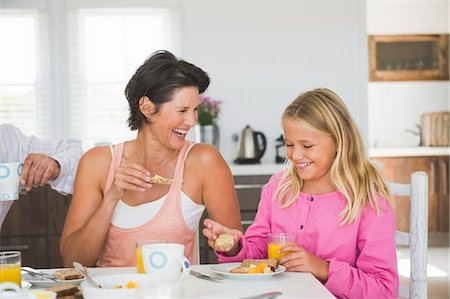 simsearch:6108-05864945,k - Woman having breakfast with her daughter at the dining table Stock Photo - Premium Royalty-Free, Code: 6108-05865814