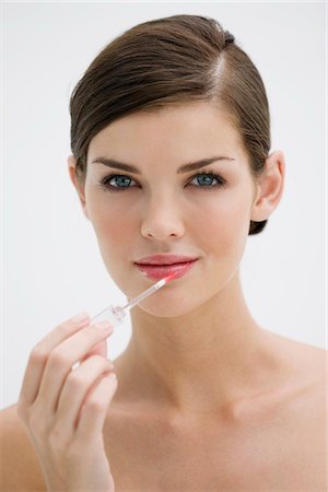 simsearch:6108-05873814,k - Fashion model applying lip gloss on her lips Stock Photo - Premium Royalty-Free, Code: 6108-05866159