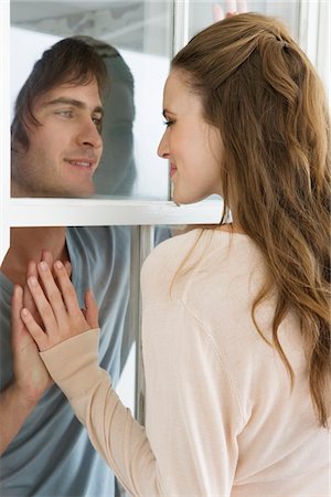 romantic women in windows - Couple looking at each other and smiling Stock Photo - Premium Royalty-Free, Code: 6108-05866188