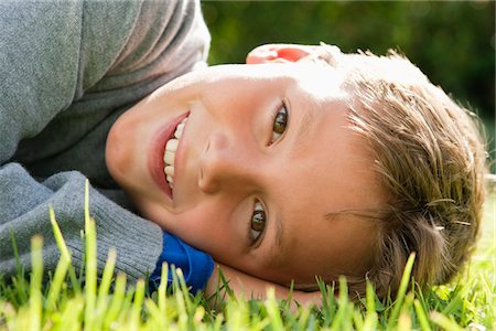 Boy lying on grass and smiling Foto de stock - Sin royalties Premium, Código: 6108-05866399