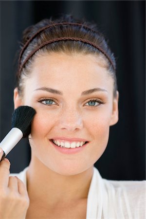 simsearch:6108-05863589,k - Portrait of a woman applying blusher on her face Foto de stock - Sin royalties Premium, Código: 6108-05866478