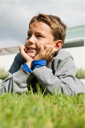 Boy lying on grass and day dreaming Foto de stock - Sin royalties Premium, Código: 6108-05866403