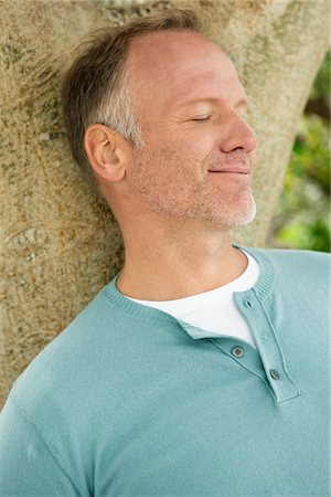 Man leaning against a tree trunk Foto de stock - Sin royalties Premium, Código: 6108-05866655