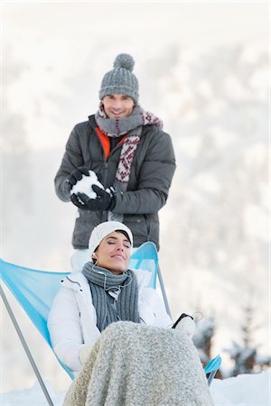 snow ball - Young man about to throw snowball at woman resting Stock Photo - Premium Royalty-Free, Code: 6108-05866879
