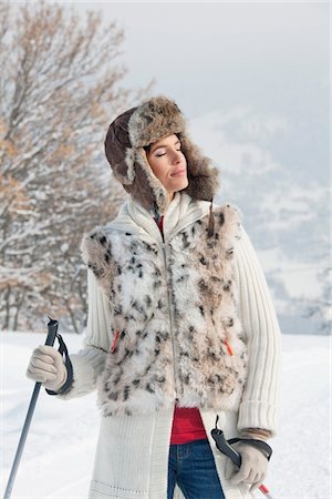 fur hat - Young woman with ski poles, eyes closed Stock Photo - Premium Royalty-Free, Code: 6108-05867044