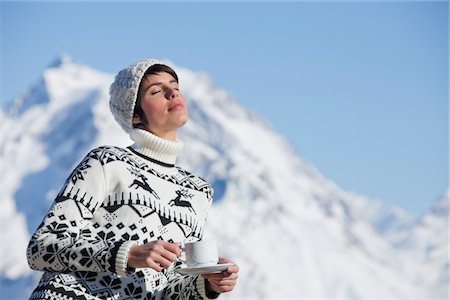 Jeune femme avec une tasse de café, profitant de soleil d'hiver, les montagnes en arrière-plan Photographie de stock - Premium Libres de Droits, Code: 6108-05867127