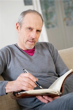 Portrait of a man writing in a personal organizer Stock Photo - Premium Royalty-Free, Code: 6108-05867340