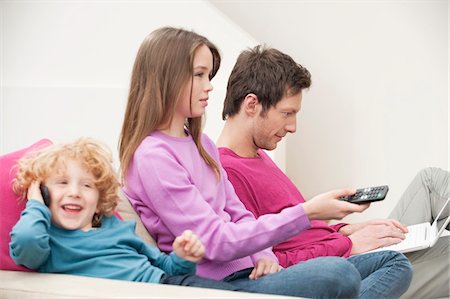 simsearch:649-07239830,k - Family sitting together involved in different activities Stock Photo - Premium Royalty-Free, Code: 6108-05867365