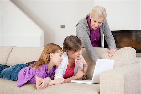 preteen girls looking older - Two girls using a laptop on a couch with their grandmother Stock Photo - Premium Royalty-Free, Code: 6108-05867584