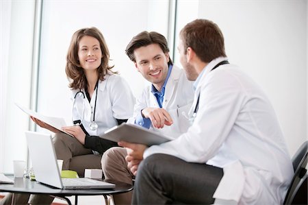 Three doctors talking to each other Stock Photo - Premium Royalty-Free, Code: 6108-05868022