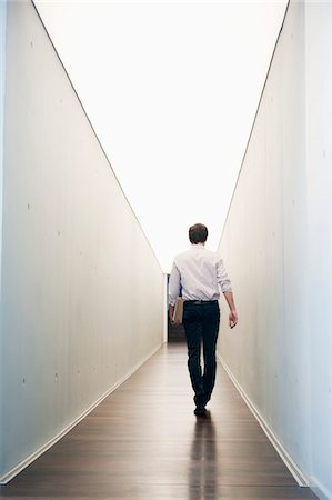 filing - Businessman walking in the corridor of an office Stock Photo - Premium Royalty-Free, Code: 6108-05868775