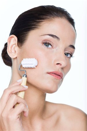 simsearch:6108-05869249,k - Young woman using facial massage roller Stock Photo - Premium Royalty-Free, Code: 6108-05869062