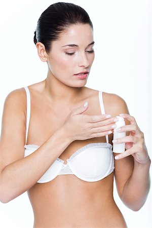 simsearch:6108-05869249,k - Young woman applying moisturizer Stock Photo - Premium Royalty-Free, Code: 6108-05869081