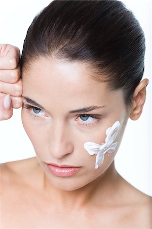 simsearch:6108-05869249,k - Young woman with moisturizer on her cheek Stock Photo - Premium Royalty-Free, Code: 6108-05869082