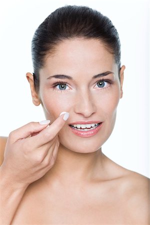 simsearch:6108-05869257,k - Young woman applying moisturizer Stock Photo - Premium Royalty-Free, Code: 6108-05869089