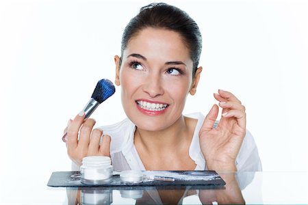 simsearch:6108-05869249,k - Young woman holding make-up brush Stock Photo - Premium Royalty-Free, Code: 6108-05869097