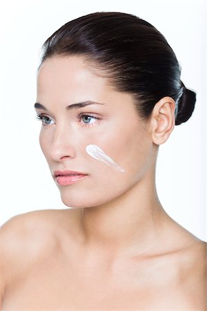 simsearch:6108-05869249,k - Young woman with moisturizer on her cheek Stock Photo - Premium Royalty-Free, Code: 6108-05869106