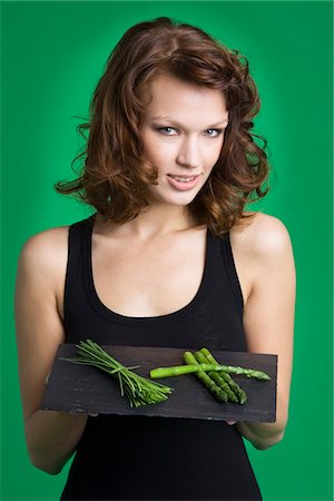 Young woman holding tray of asparagus and chives Stock Photo - Premium Royalty-Free, Code: 6108-05869135