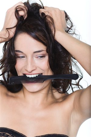 simsearch:6108-05869249,k - Young woman with hands in hair, biting comb Stock Photo - Premium Royalty-Free, Code: 6108-05869237