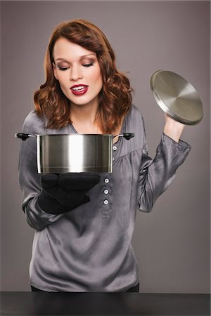 simsearch:6108-05869331,k - Young woman looking at content of stew pot Stock Photo - Premium Royalty-Free, Code: 6108-05869340