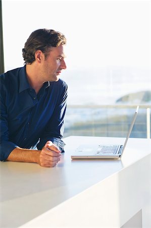 simsearch:6108-06907153,k - Side profile of a mid adult man looking at a laptop Stock Photo - Premium Royalty-Free, Code: 6108-05869674