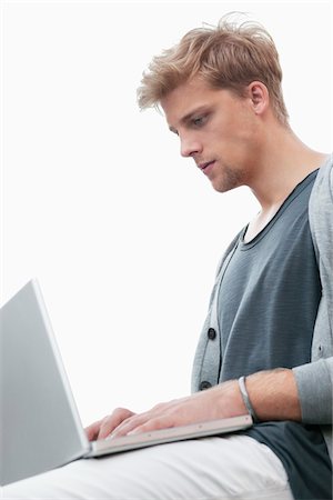simsearch:6108-06904945,k - Young man using a laptop Stock Photo - Premium Royalty-Free, Code: 6108-05869613