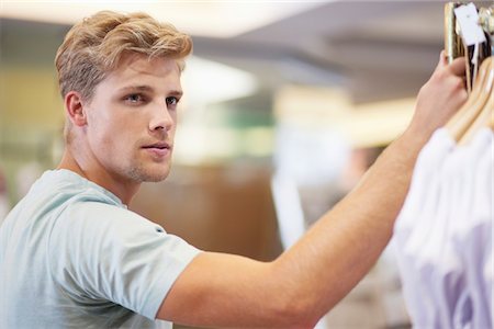 south africa and clothing store - Young man standing in a clothing store Stock Photo - Premium Royalty-Free, Code: 6108-05869615