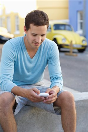 road, south africa - Mid adult man text messaging with a mobile phone Stock Photo - Premium Royalty-Free, Code: 6108-05869632