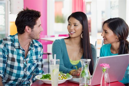 ethnic group of friends - Friends looking at each other while eating food in a restaurant Stock Photo - Premium Royalty-Free, Code: 6108-05869842