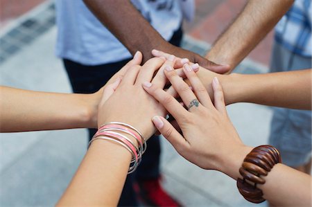 Close-up of human hands stacked upon one another Stock Photo - Premium Royalty-Free, Code: 6108-05869818