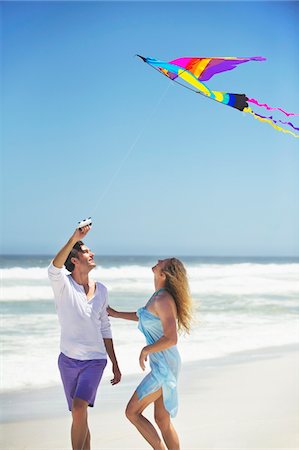 flying kites pictures - Couple flying kite on the beach Stock Photo - Premium Royalty-Free, Code: 6108-05869958