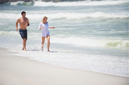 surf couple - Mid couple adulte en cours d'exécution sur la plage Photographie de stock - Premium Libres de Droits, Code: 6108-05869995